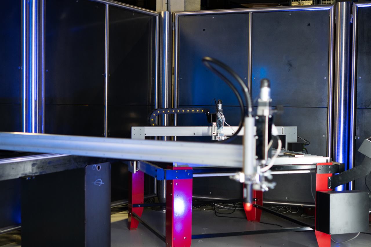 CNC-Plasmaschneidanlage mit Führungsmaschine und Plasmabrenner in einer dunklen Fertigungshalle